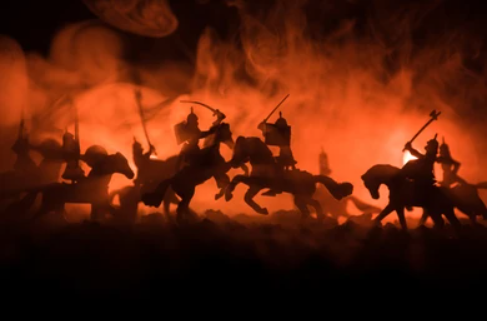 Siluetas luchando a caballo entre llamas